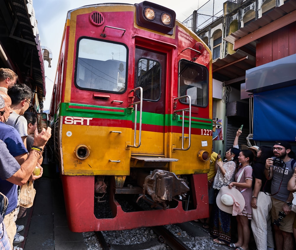 a group of people standing next to a train