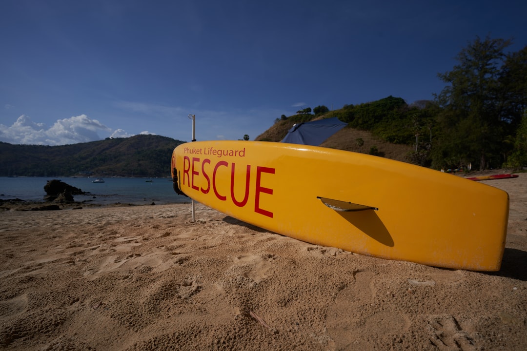 a yellow surfboard sitting on top of a sandy beach,