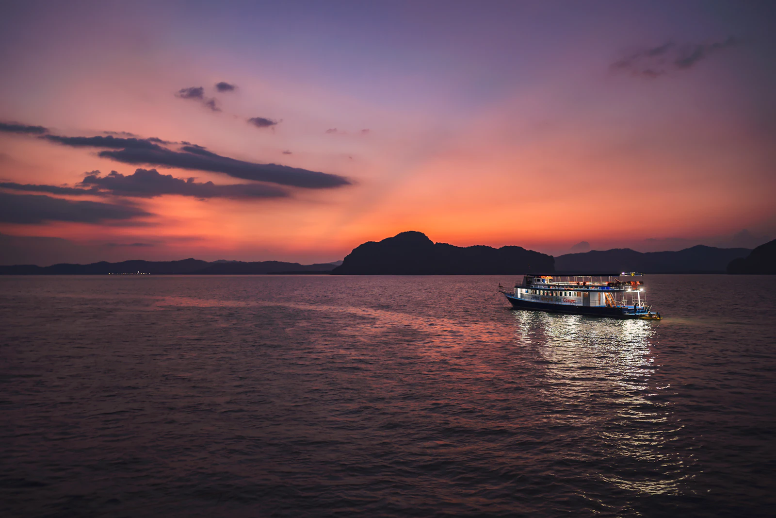 A boat on calm water at golden hour.