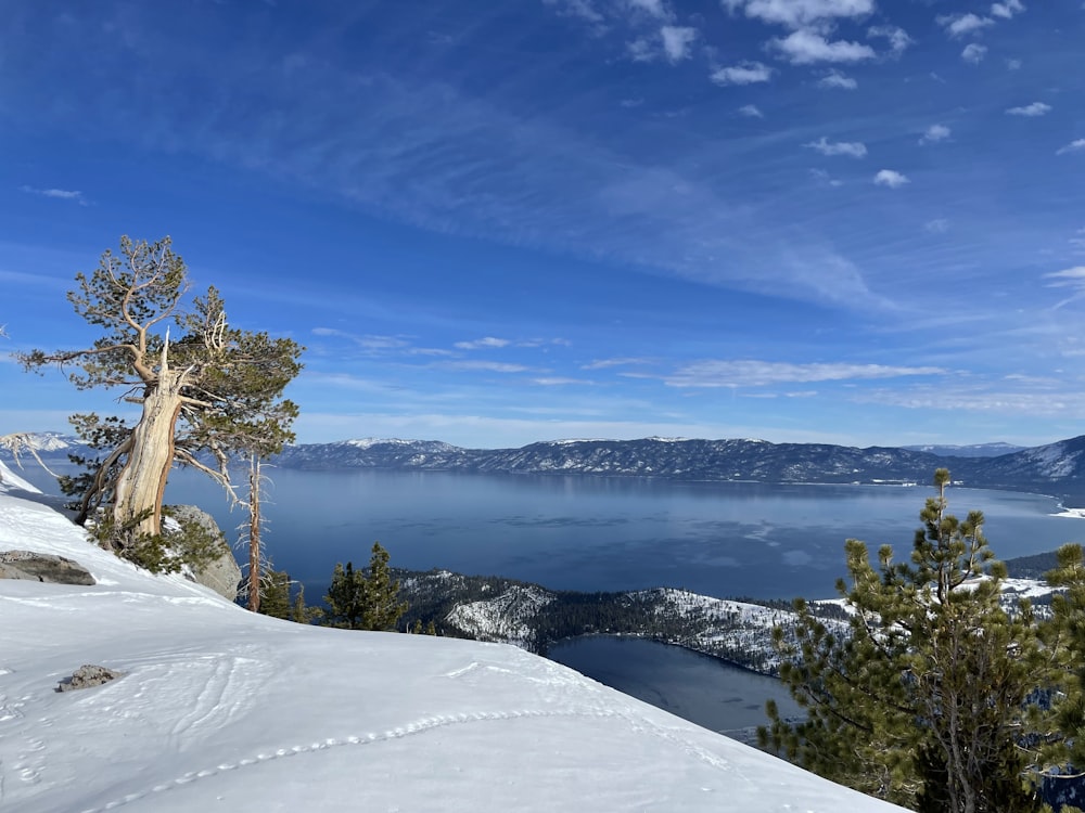 a snow covered hill with a lake in the background