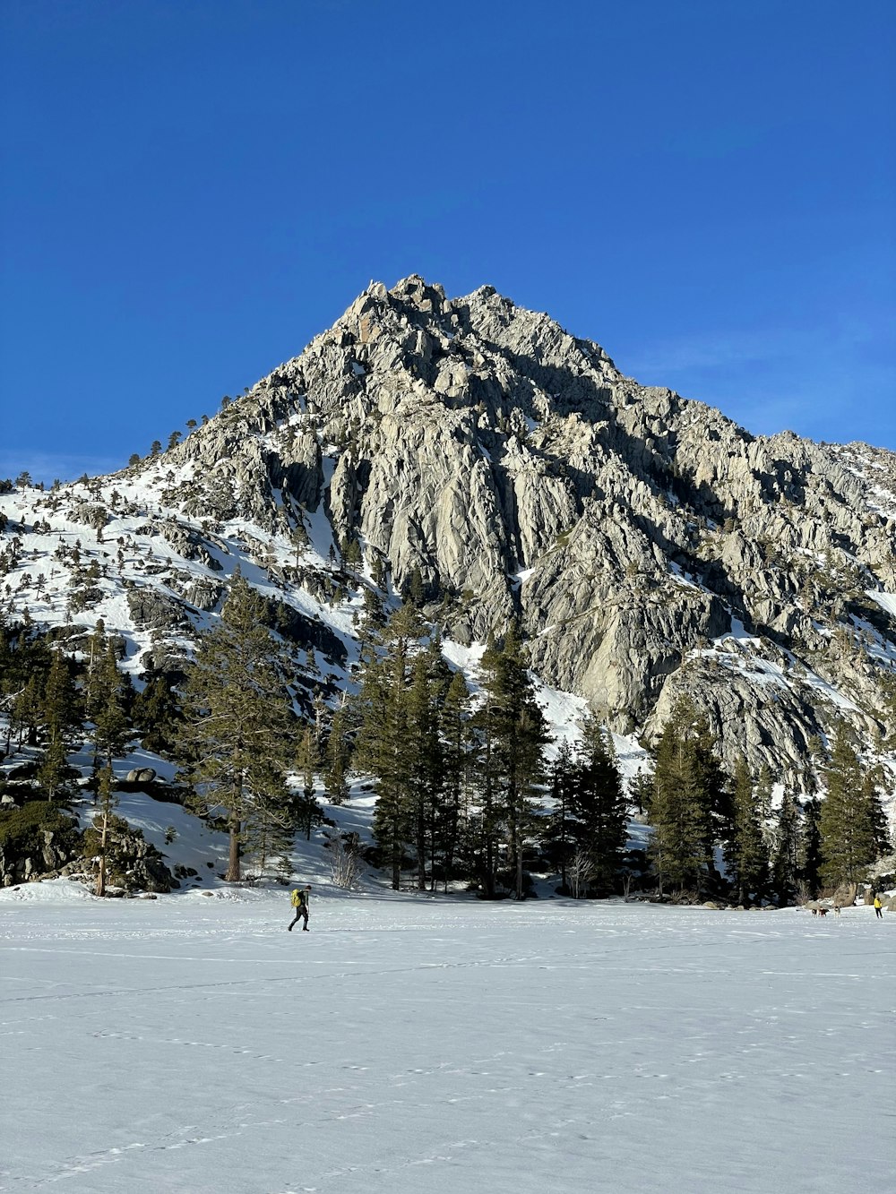 a person skiing in the snow near a mountain