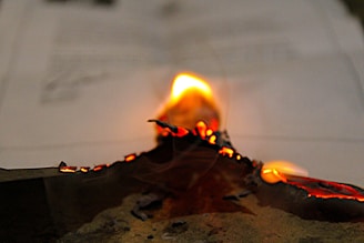 A close-up of aged parchment with glowing ember particles.