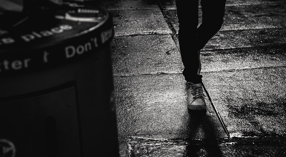 a person walking down a sidewalk in the rain