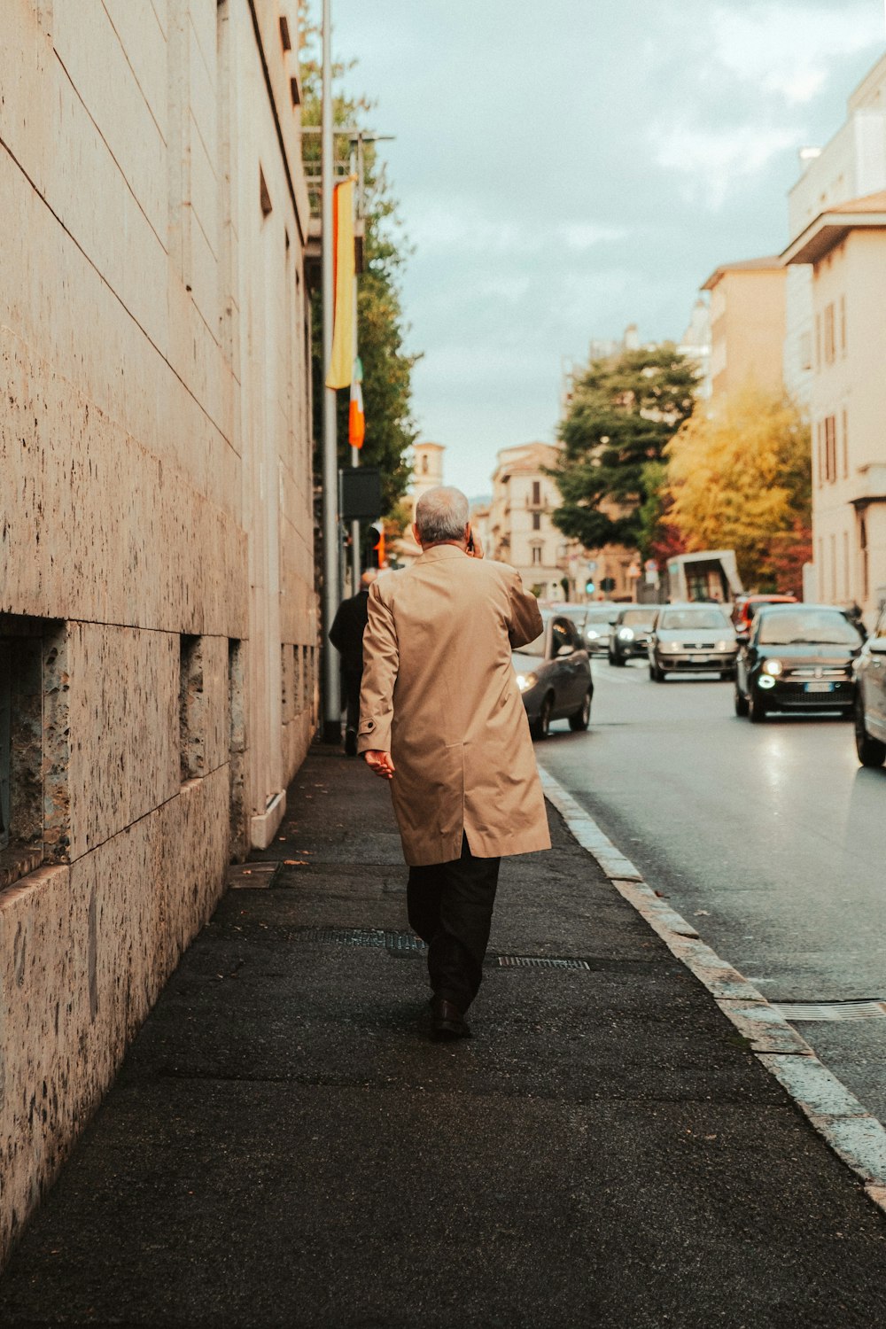 a man walking down a street next to a building