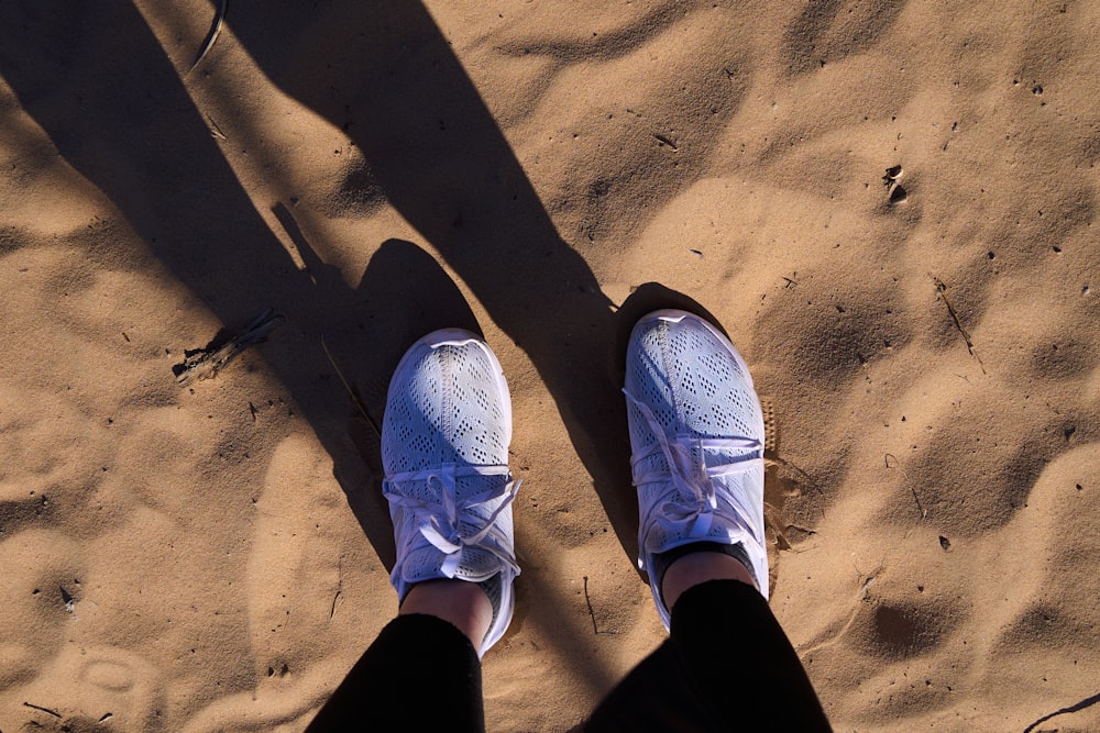 a person standing in the sand with their shoes on