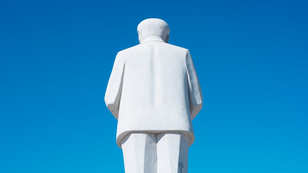Une statue d’un homme en costume blanc
