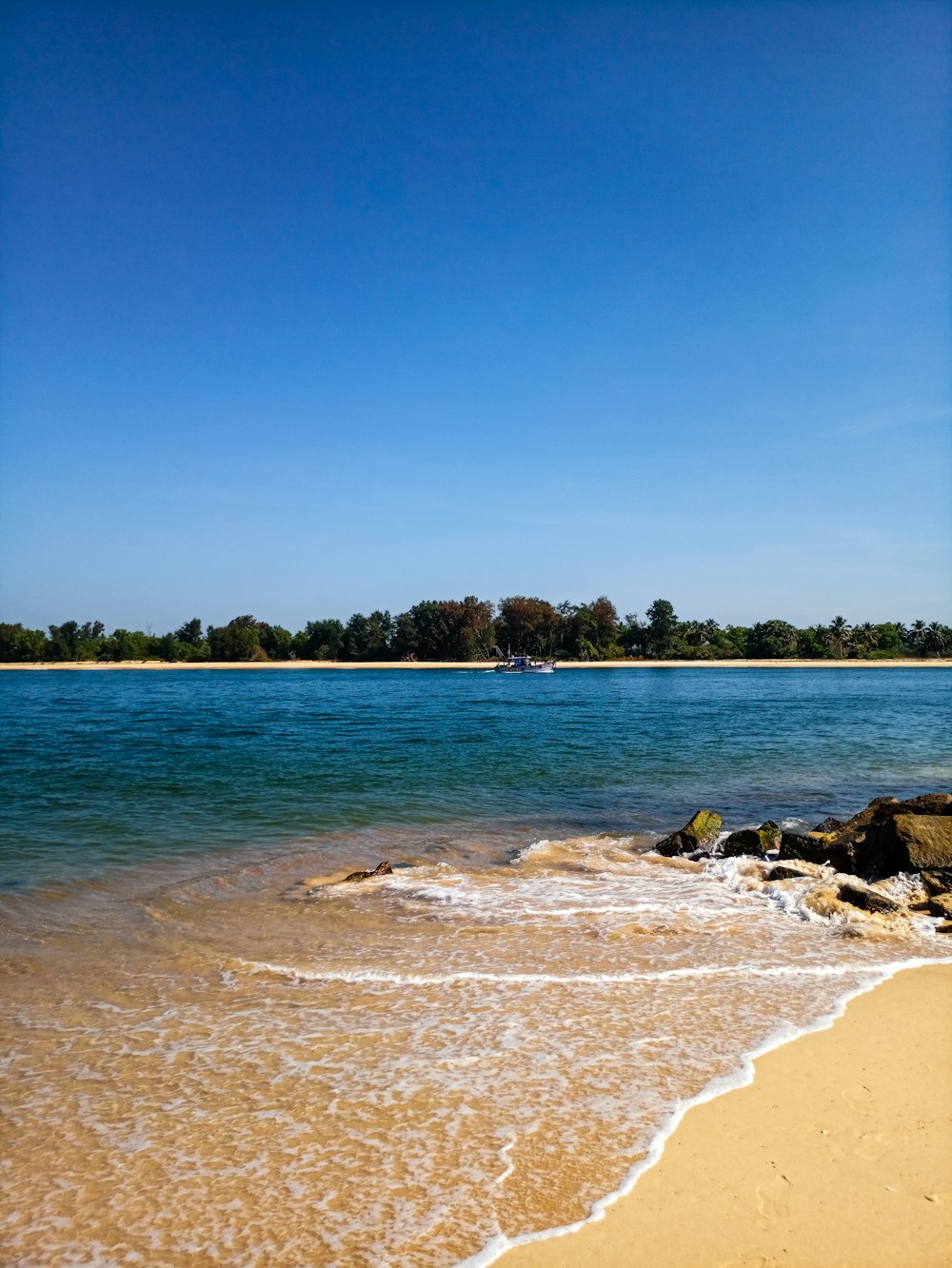 a sandy beach with waves coming in to shore