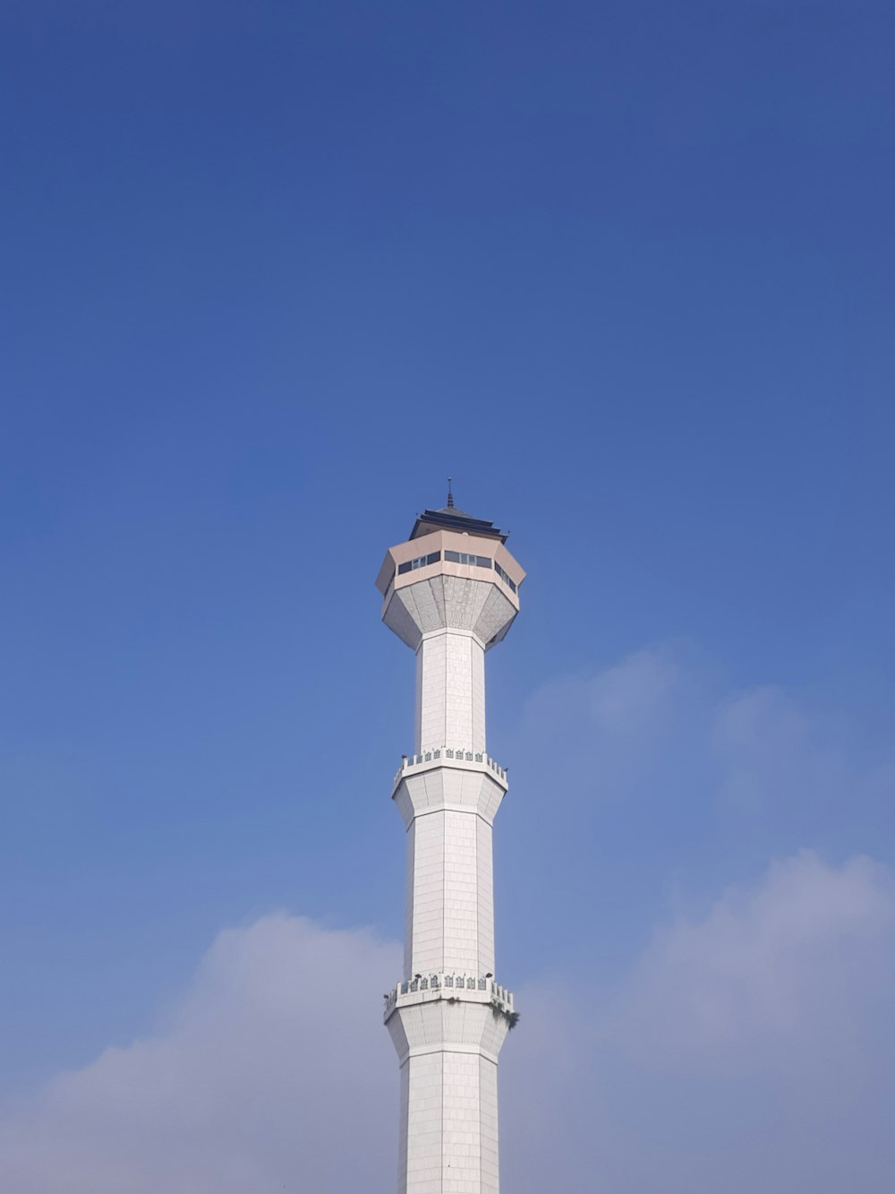 Ein hoher weißer Turm mit einer Uhr auf der Spitze