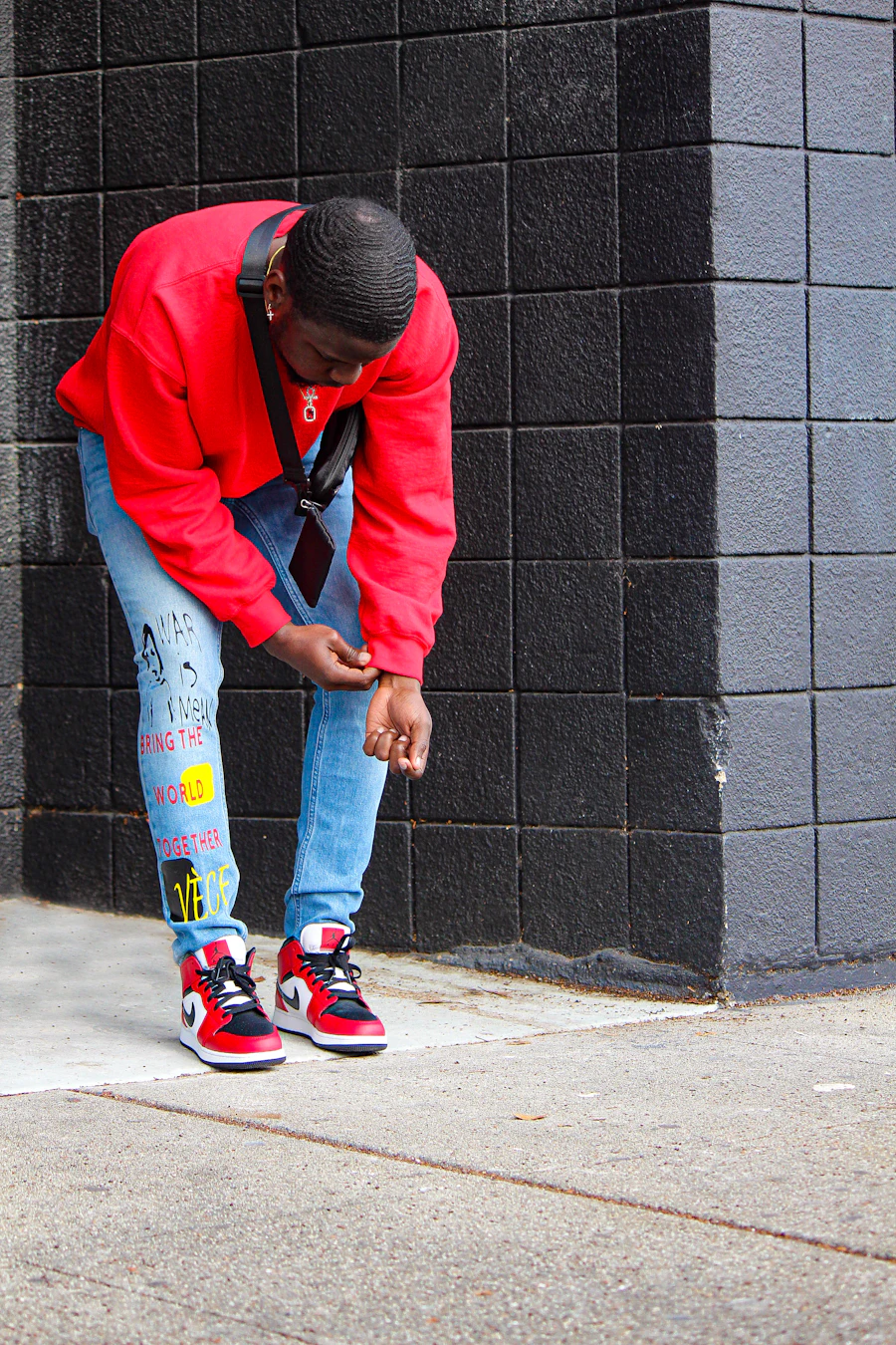 Man in a red jacket against a black wall