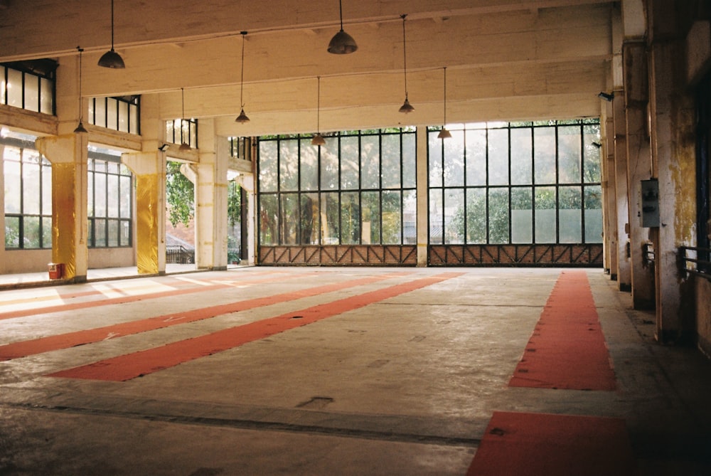 an empty room with large windows and a red carpet