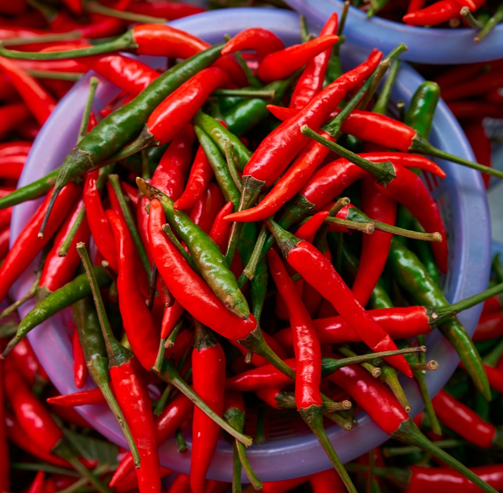 Un montón de pimientos rojos sentados encima de un plato azul