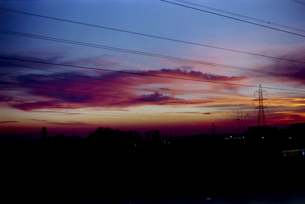 a view of a sunset with power lines in the background