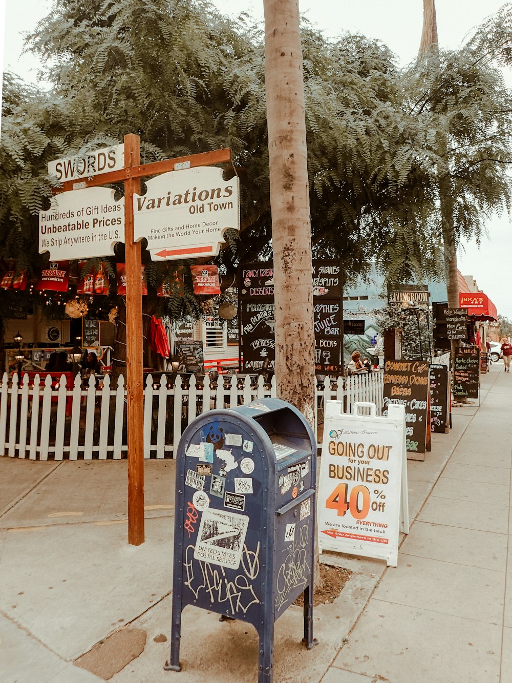 a blue mailbox sitting on the side of a road