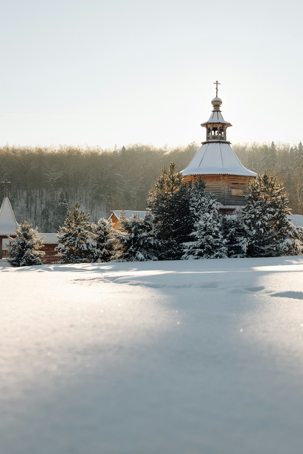 a church with a cross on top of it in the snow