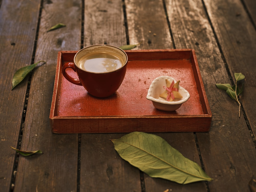 a cup of coffee sitting on top of a wooden tray