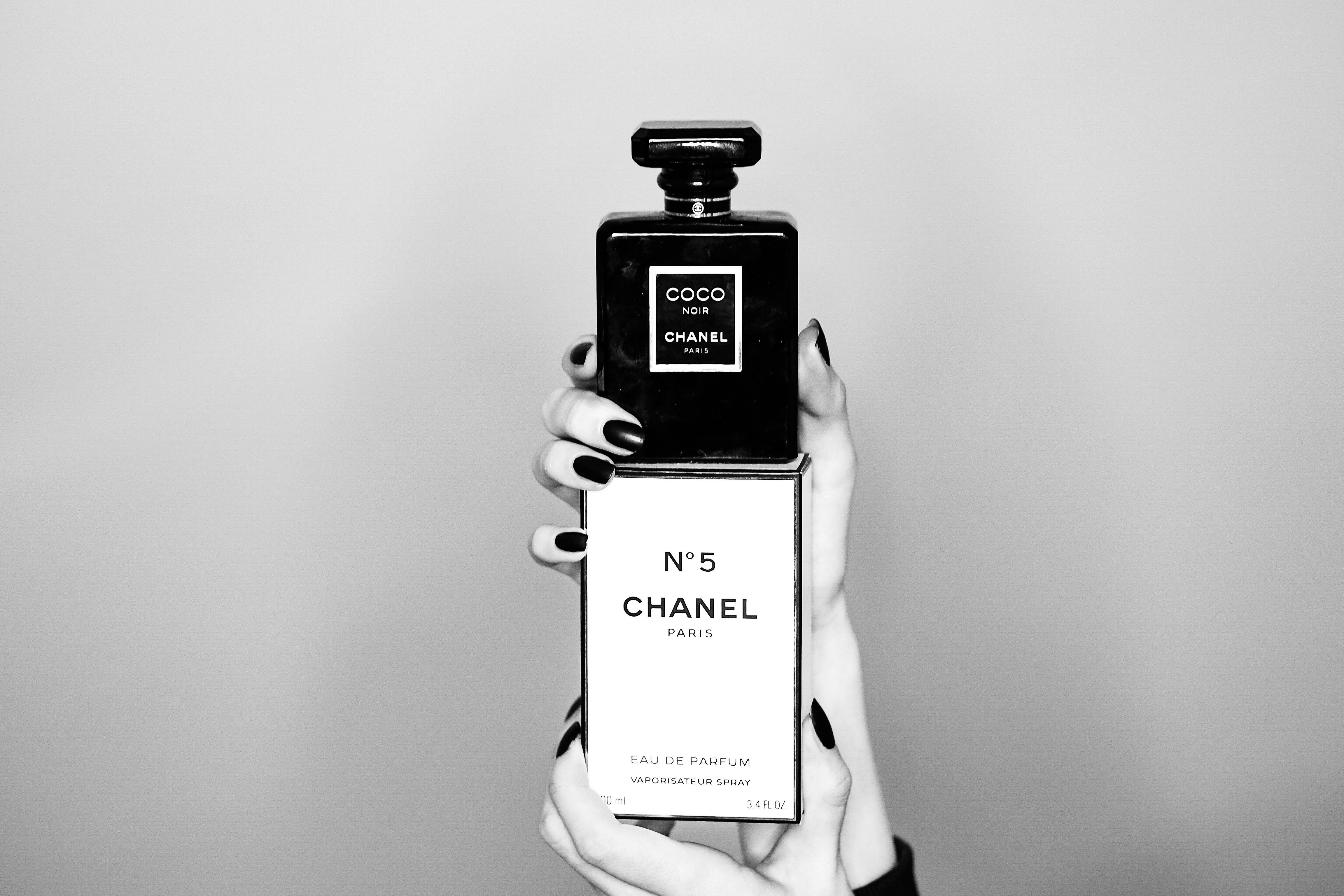 a woman holding a bottle of chanel no 5