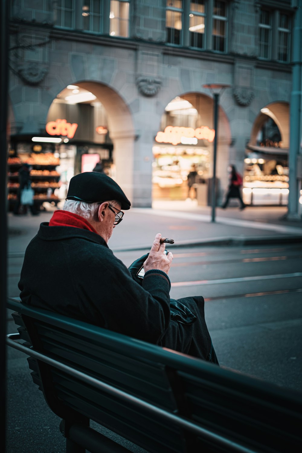 a man sitting on a bench looking at his cell phone