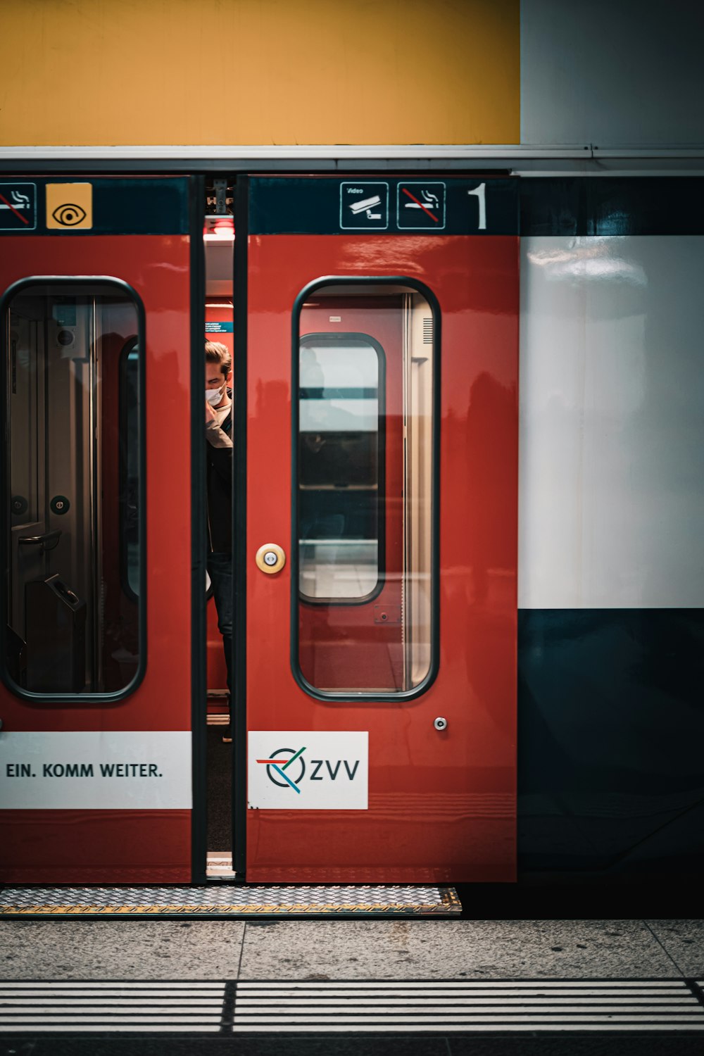 a red train with its doors open on a platform