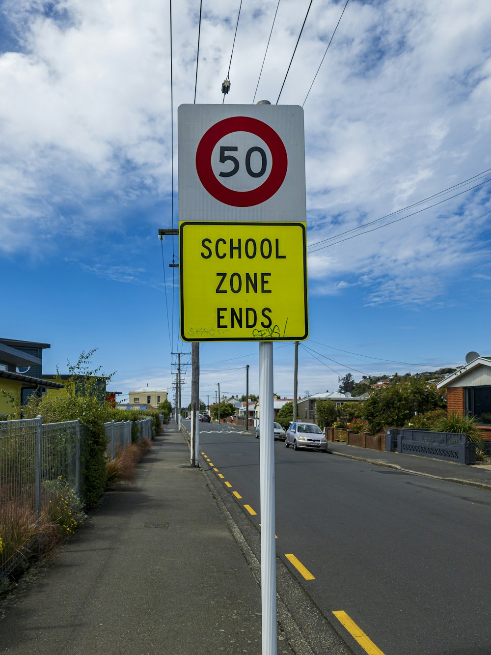 a yellow and white sign that says school zone ends
