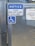 A metal gate with a sign instructing to keep it closed at all times. The sign is blue and white, featuring a notice and a wheelchair accessibility symbol. Chains are visible securing the gate, which has a grid-like metal pattern.