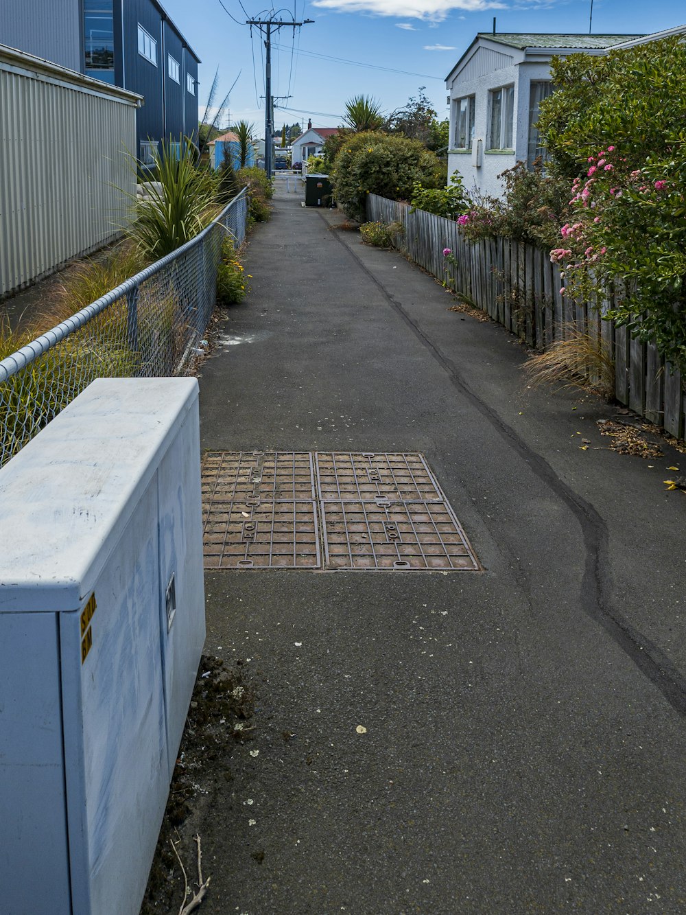 a long narrow road with a metal fence on the side