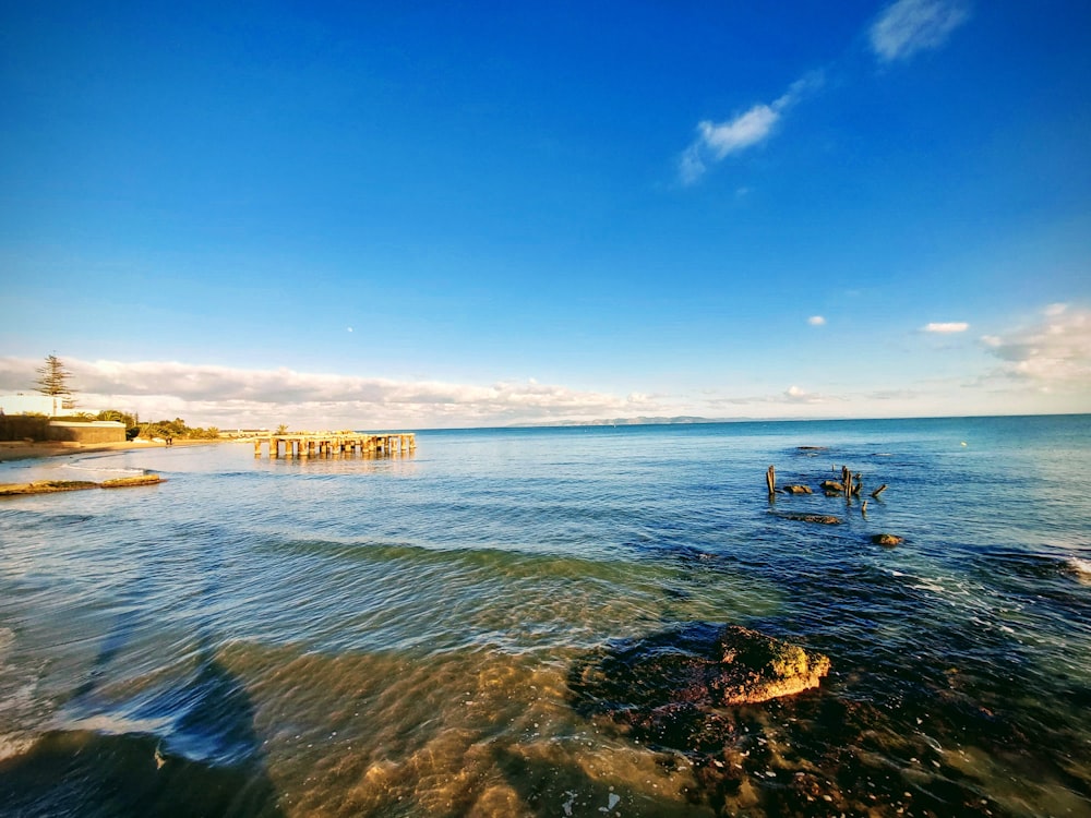 a body of water with a pier in the background