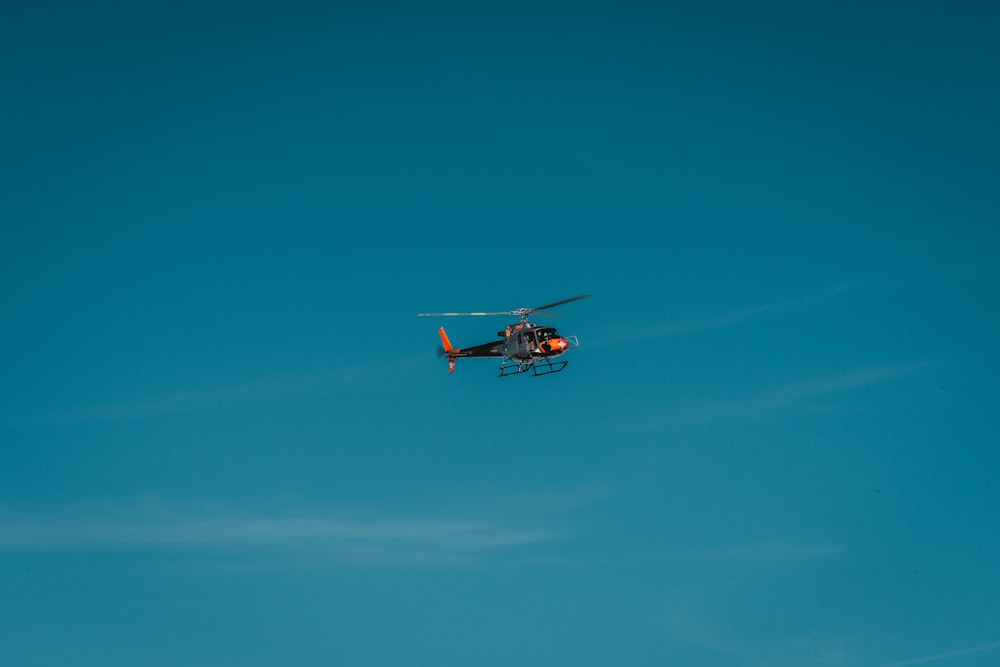 a helicopter flying through a blue sky on a clear day