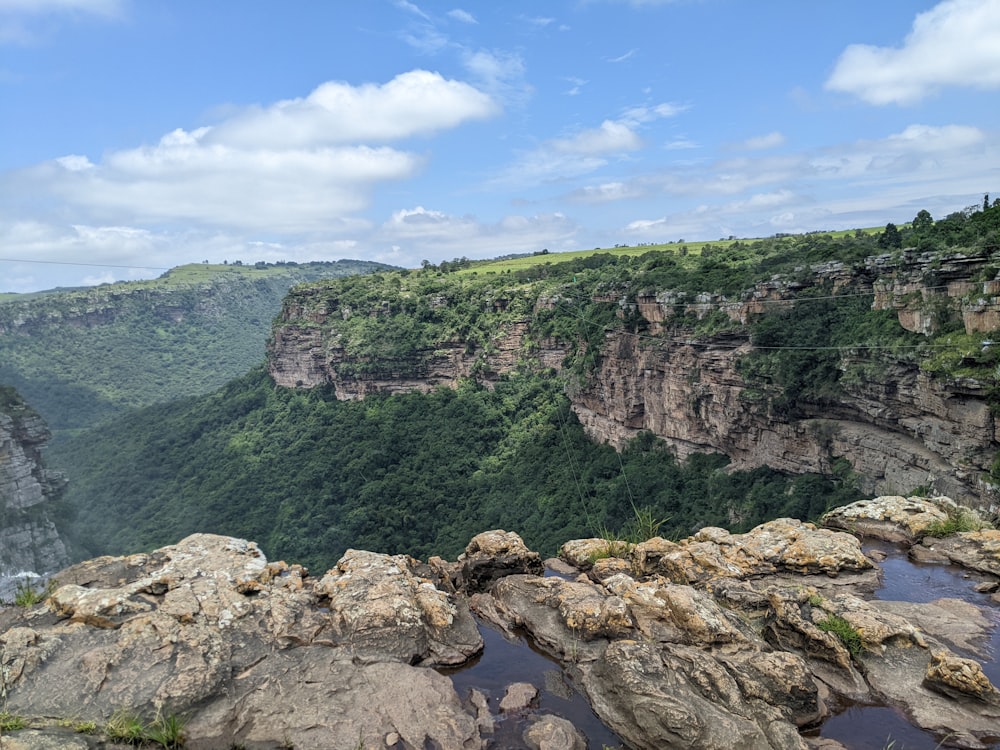 a view of a rocky cliff with a river running through it