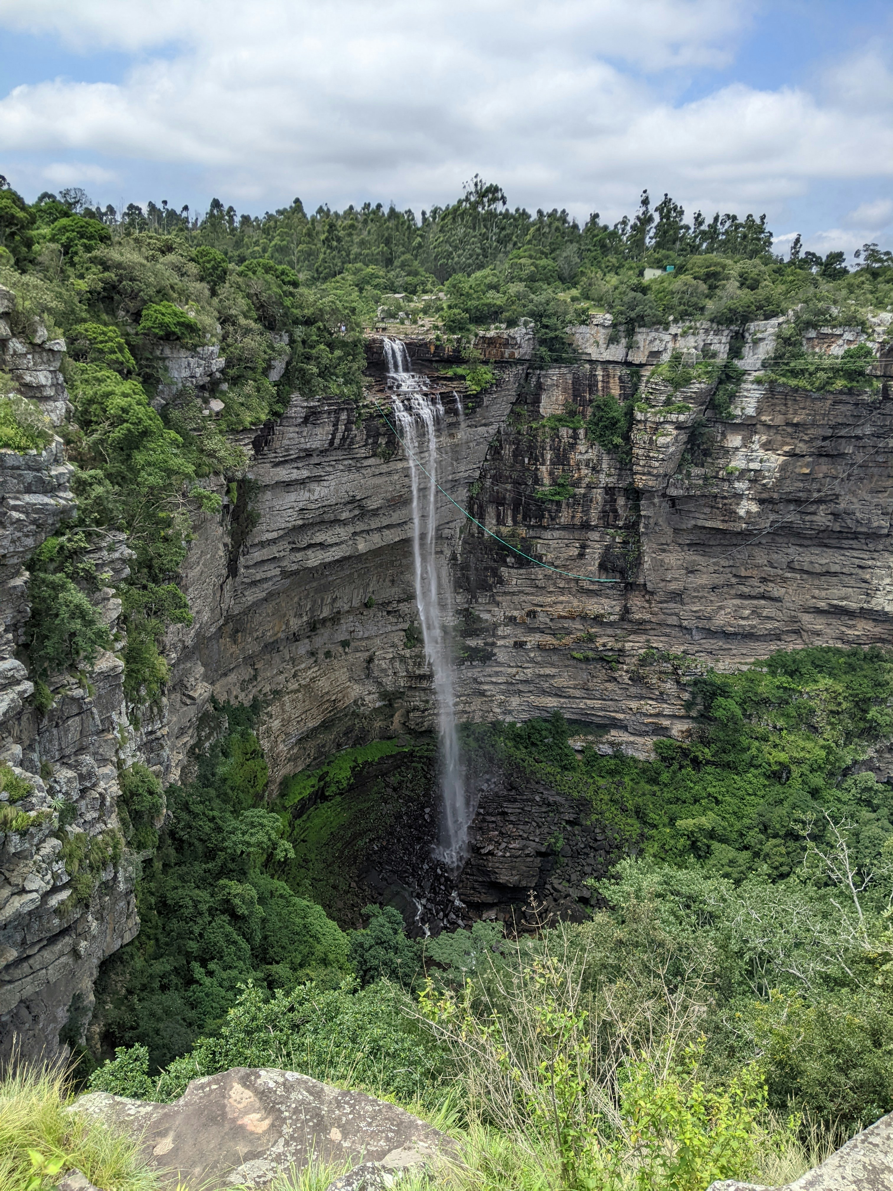 a waterfall is seen from the top of a cliff