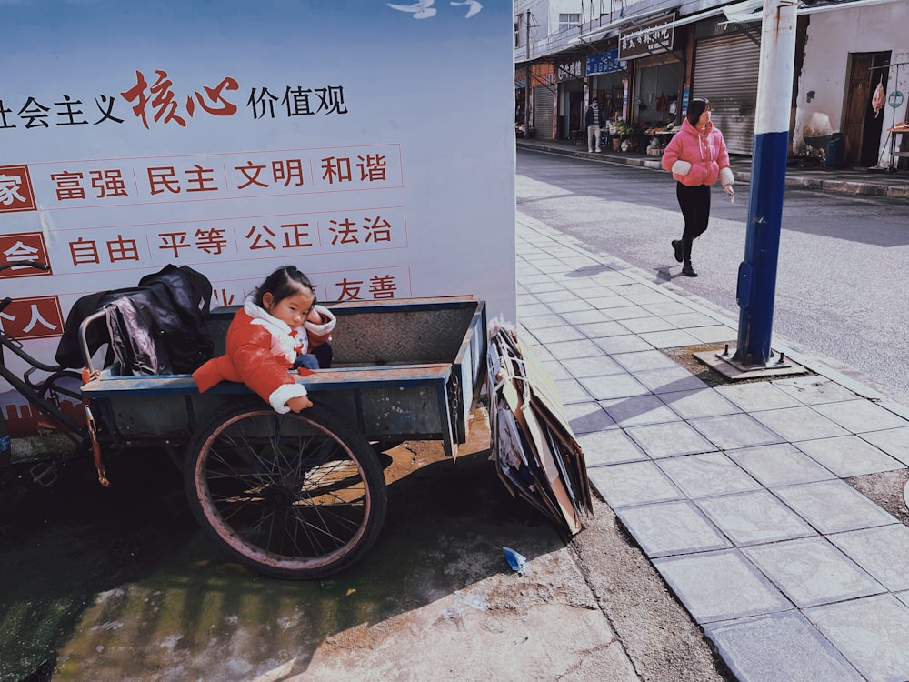 a woman in a red jacket sitting on a cart