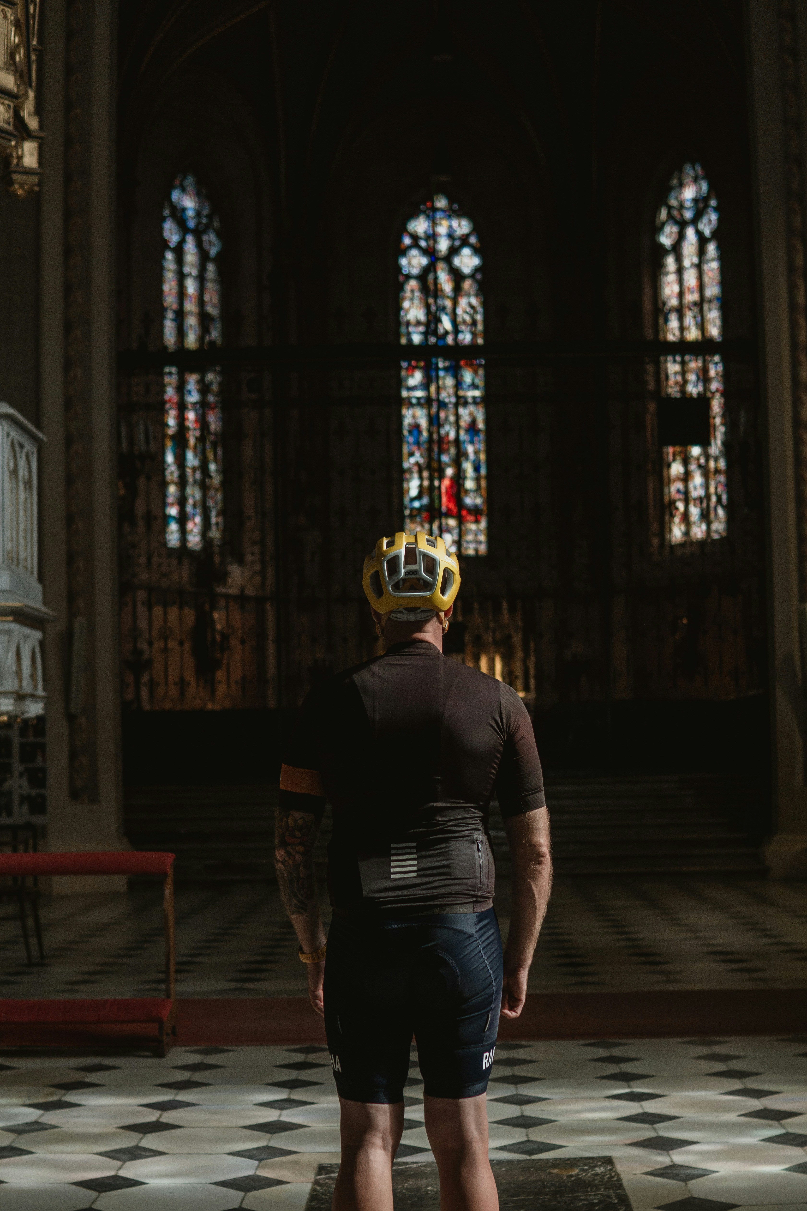 a man with a crown on his head standing in front of a stained glass window