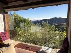 Cozy room with large window overlooking tea gardens at sunrise.