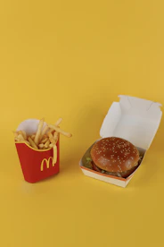 a mcdonald's hamburger and french fries on a yellow background