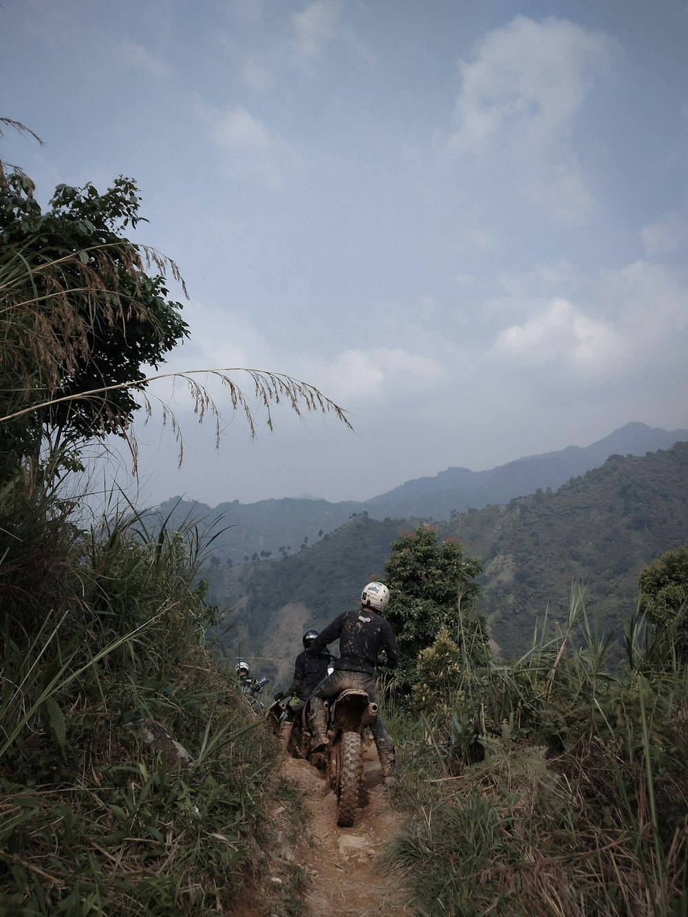 a man riding a motorcycle down a dirt road