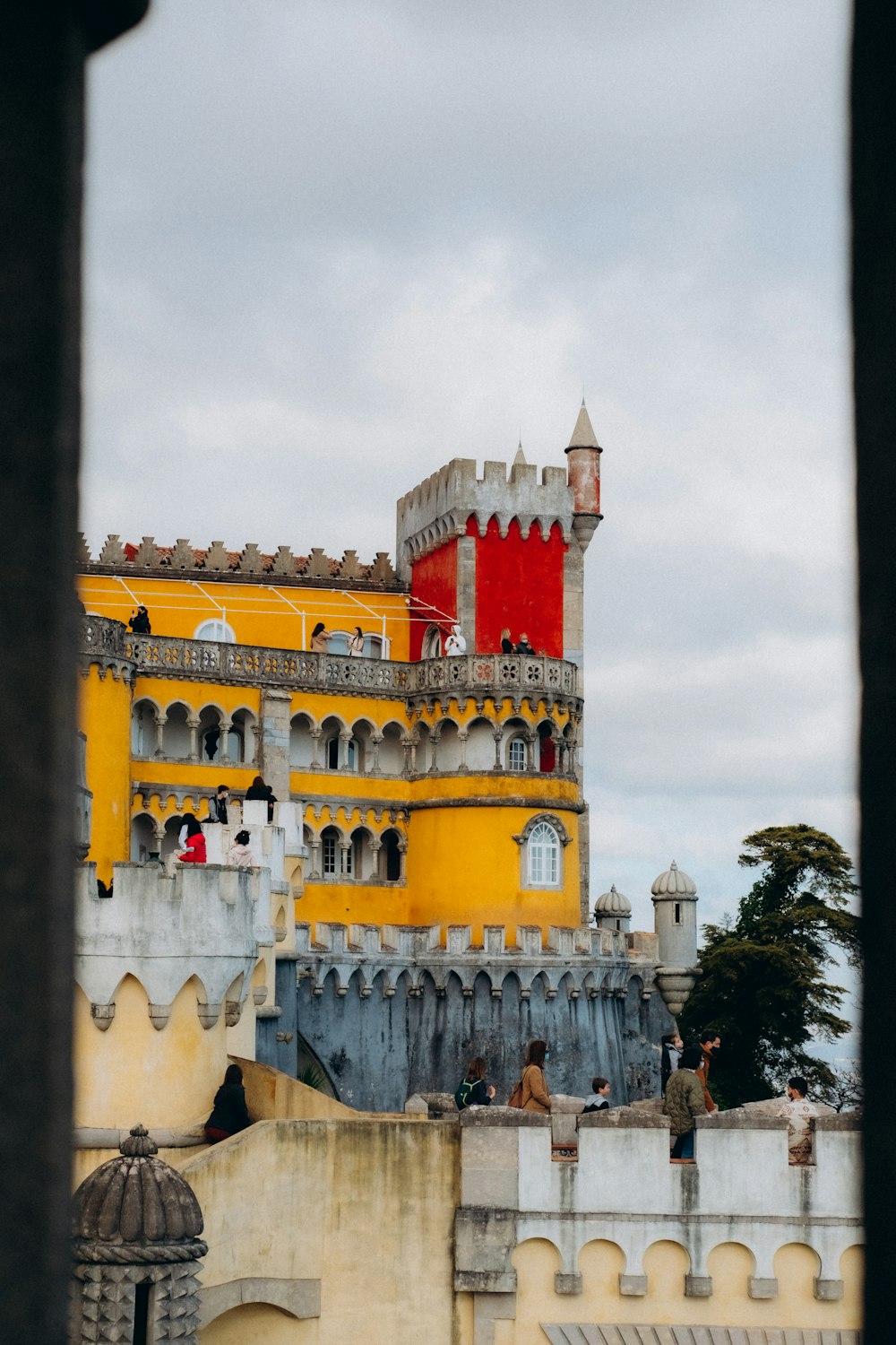 a large yellow building with a red tower