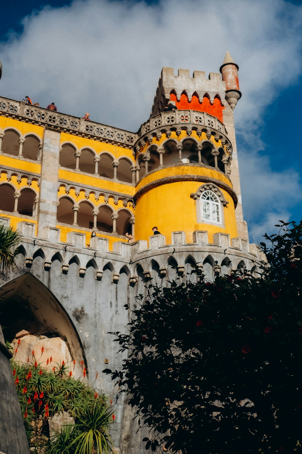 a large yellow castle with a clock on it's side