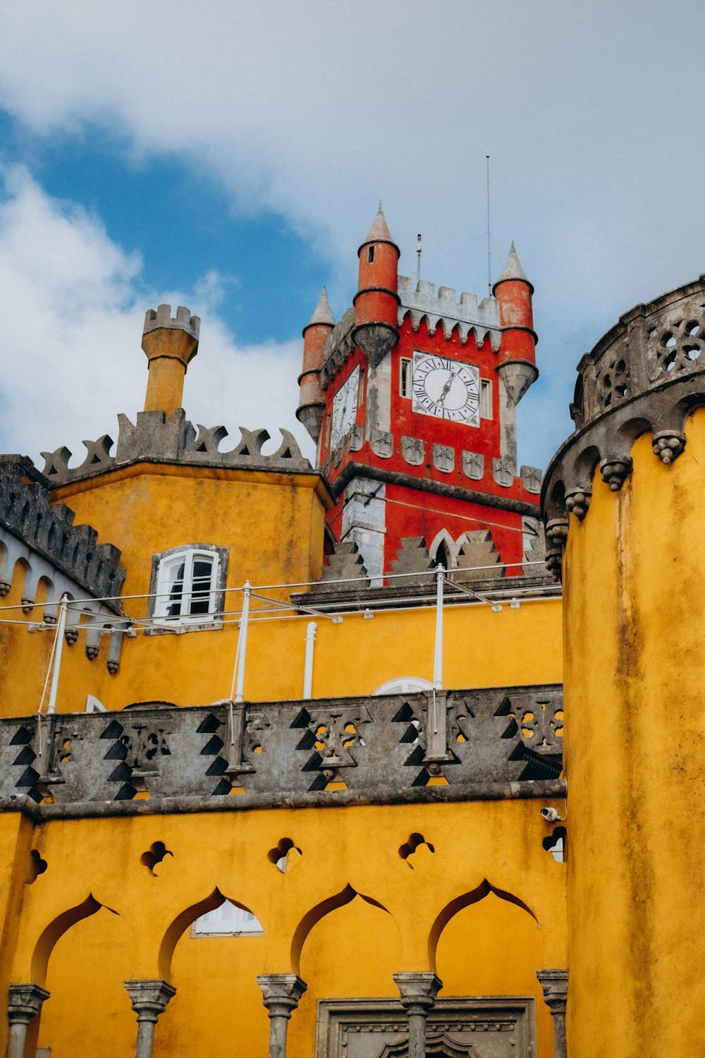 a large yellow building with a clock on it's side