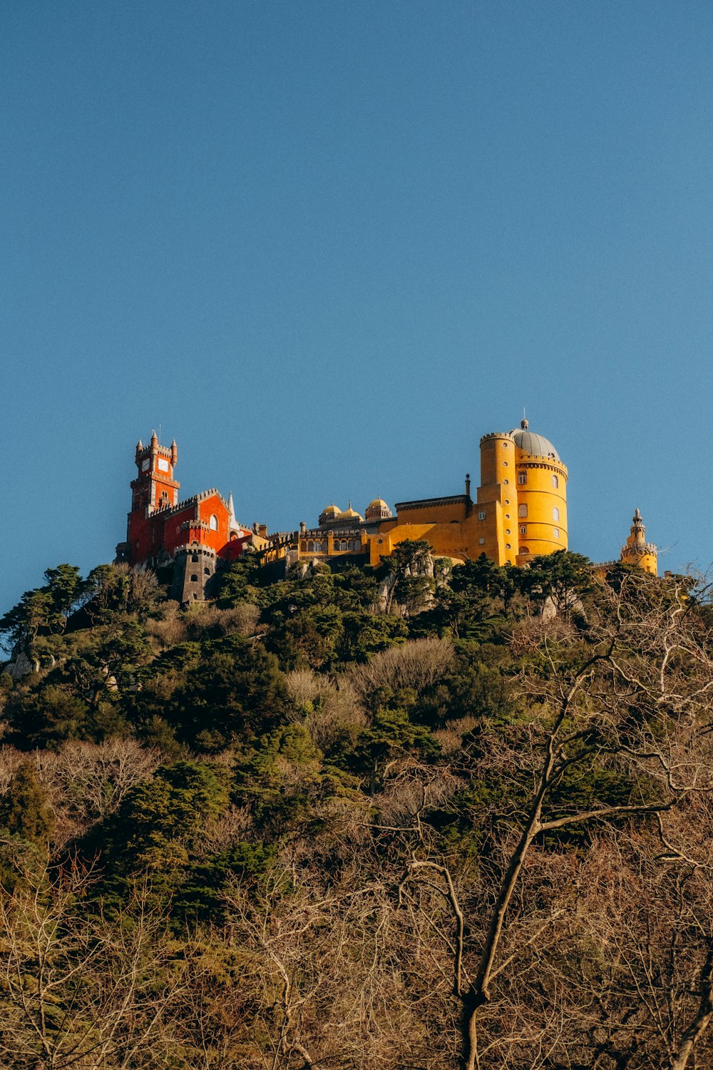 a large yellow building on top of a hill