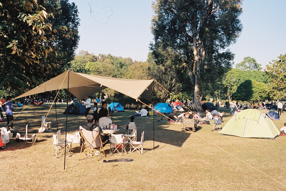 a group of people sitting in chairs under a tent