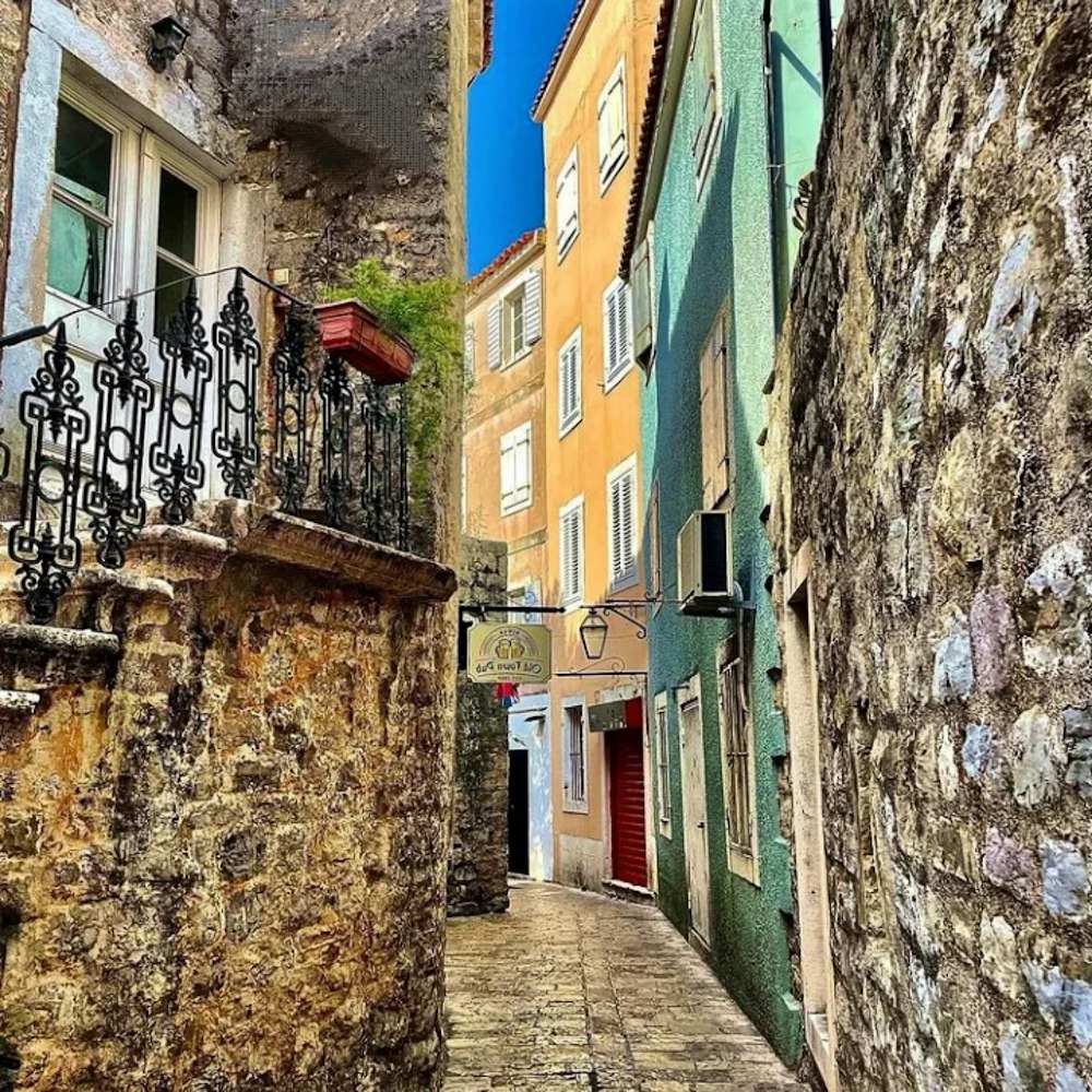 a narrow alley with a wrought iron railing