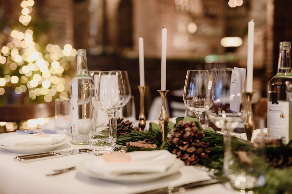 a table is set with wine glasses, plates and silverware