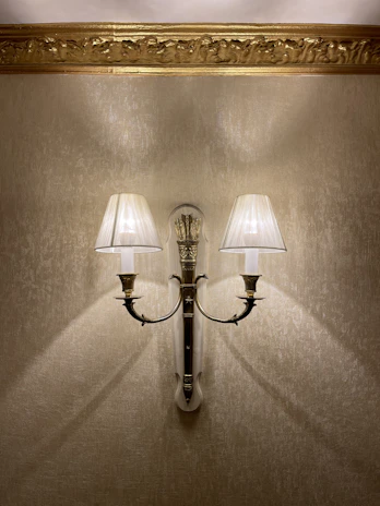 Elegant wall sconces framing a vintage mirror, adding charm to a hallway.