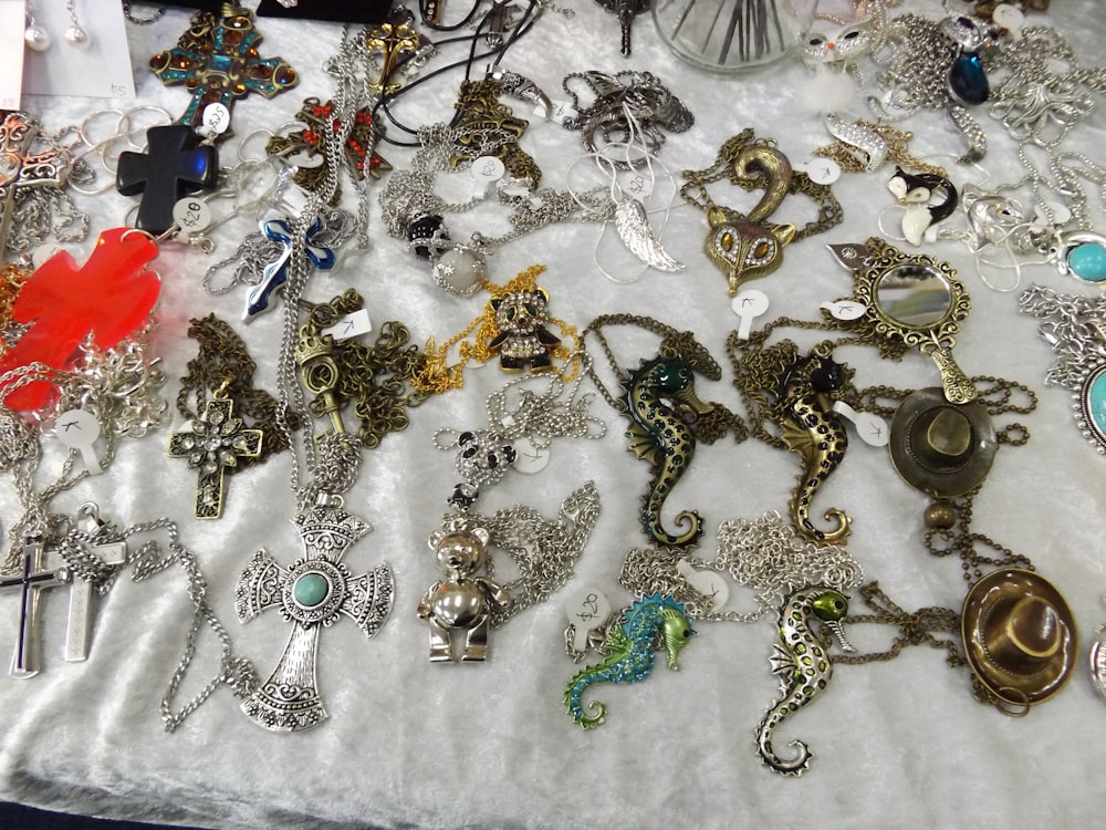 a table topped with lots of different types of necklaces