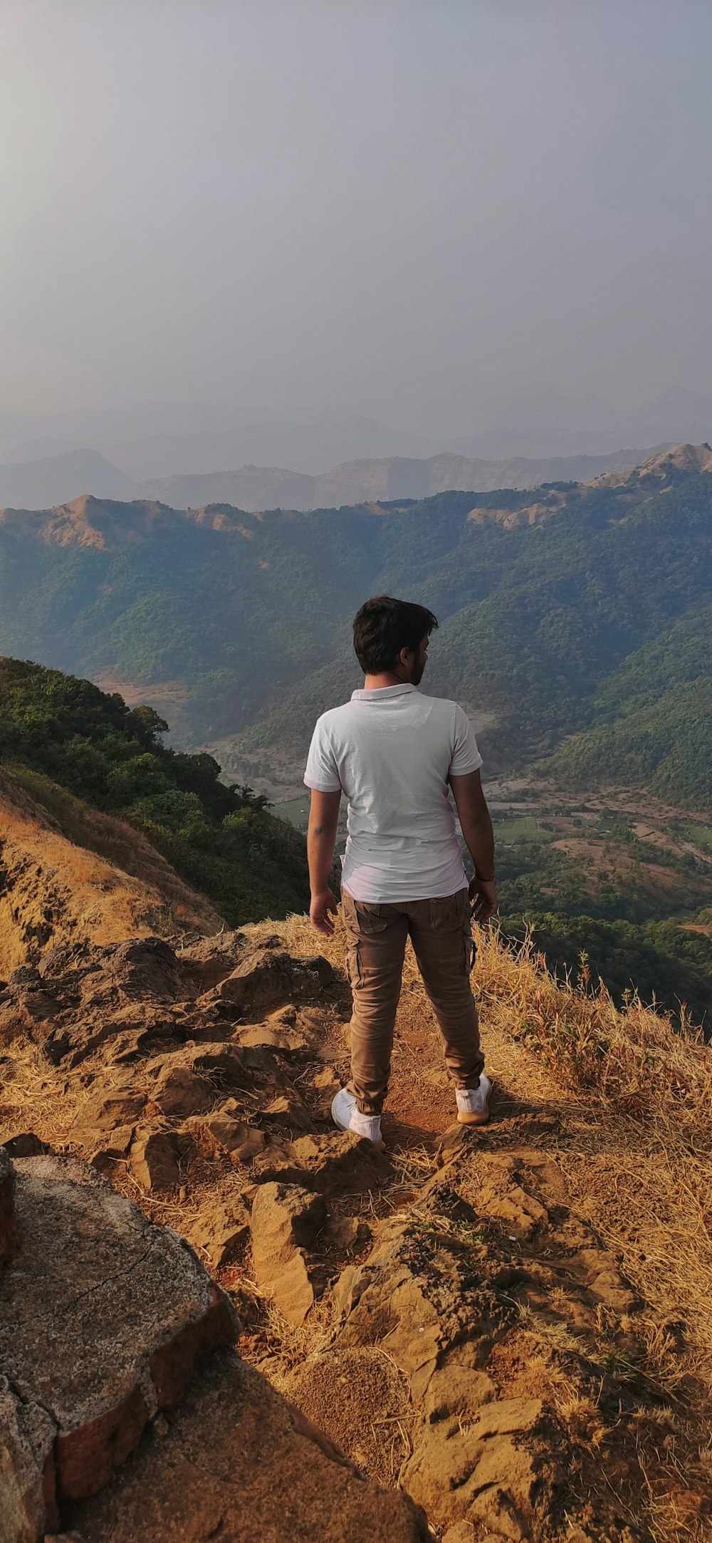 a man standing on top of a mountain overlooking a valley