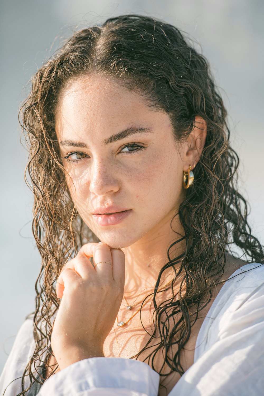 a woman with curly hair wearing a white dress