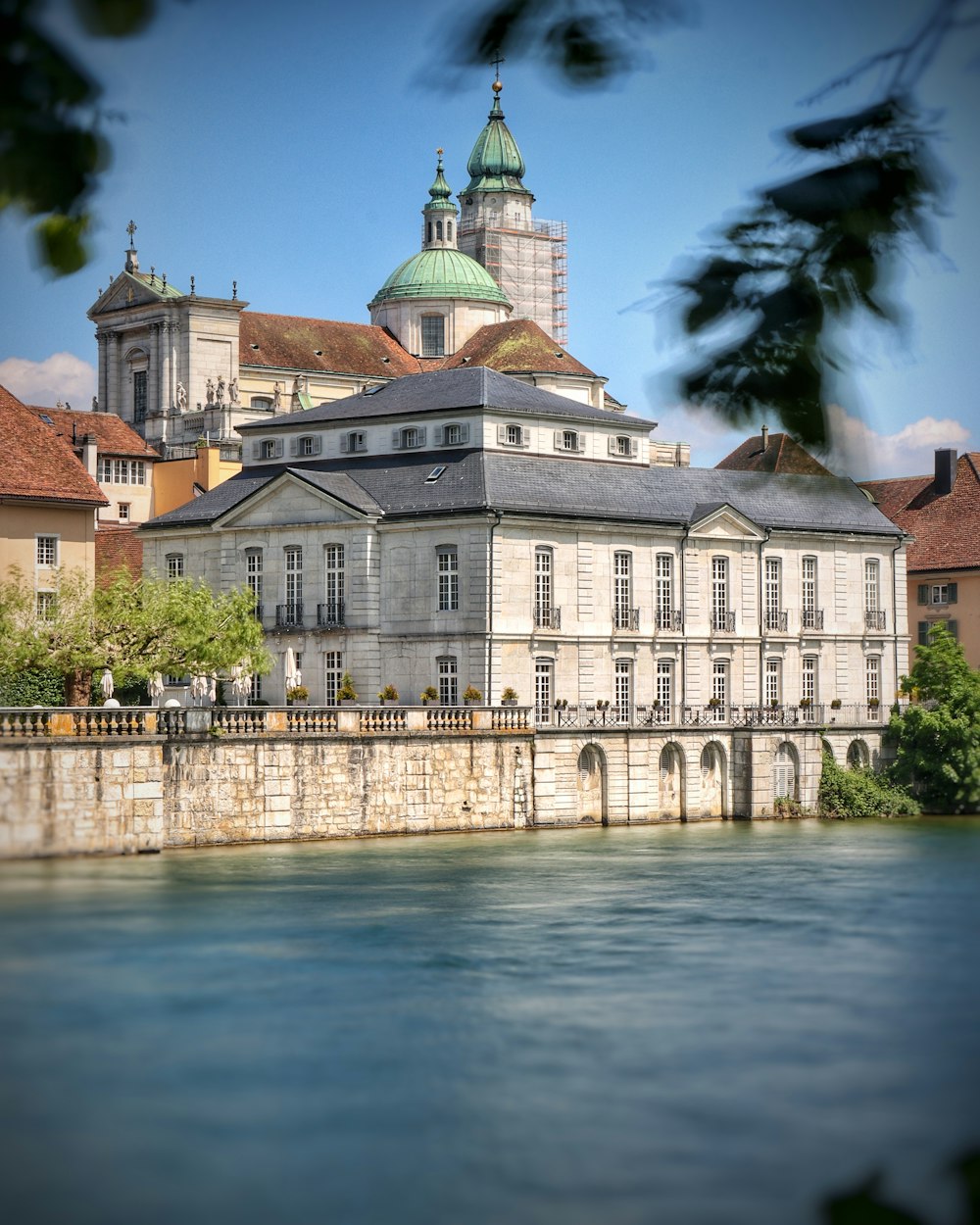 un grand bâtiment assis à côté d’un plan d’eau