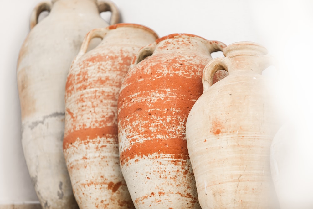 a row of vases sitting on top of a shelf