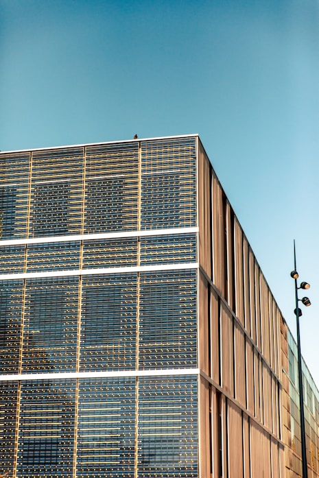 a tall building with lots of windows next to a street light