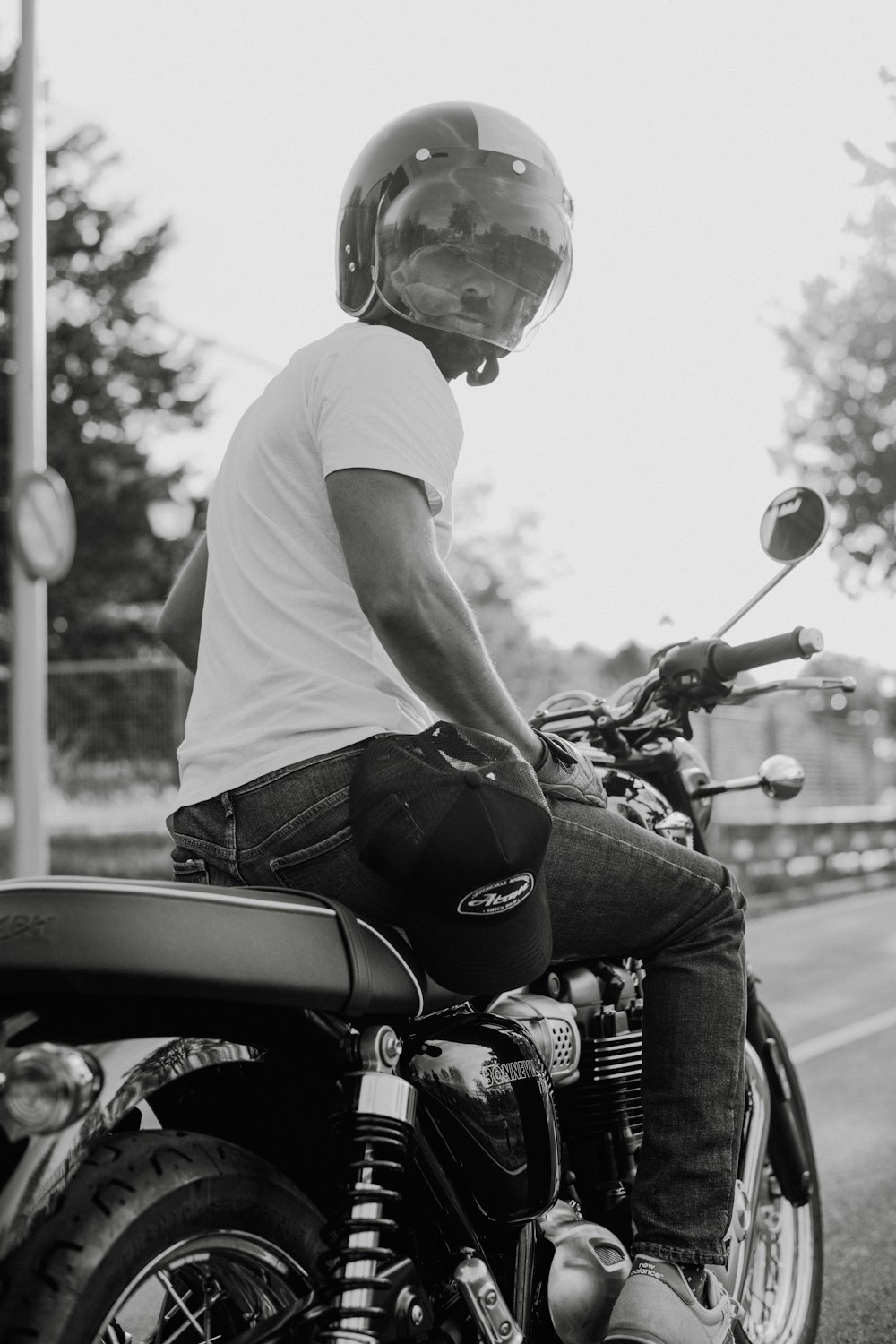 a man riding on the back of a motorcycle down a street