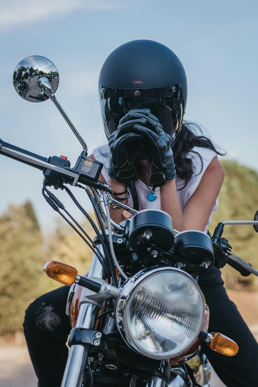 a woman sitting on a motorcycle with a helmet on